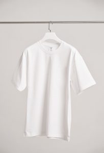 Simple white t-shirt hanging in a modern Shanghai boutique, emphasizing fashion minimalism.